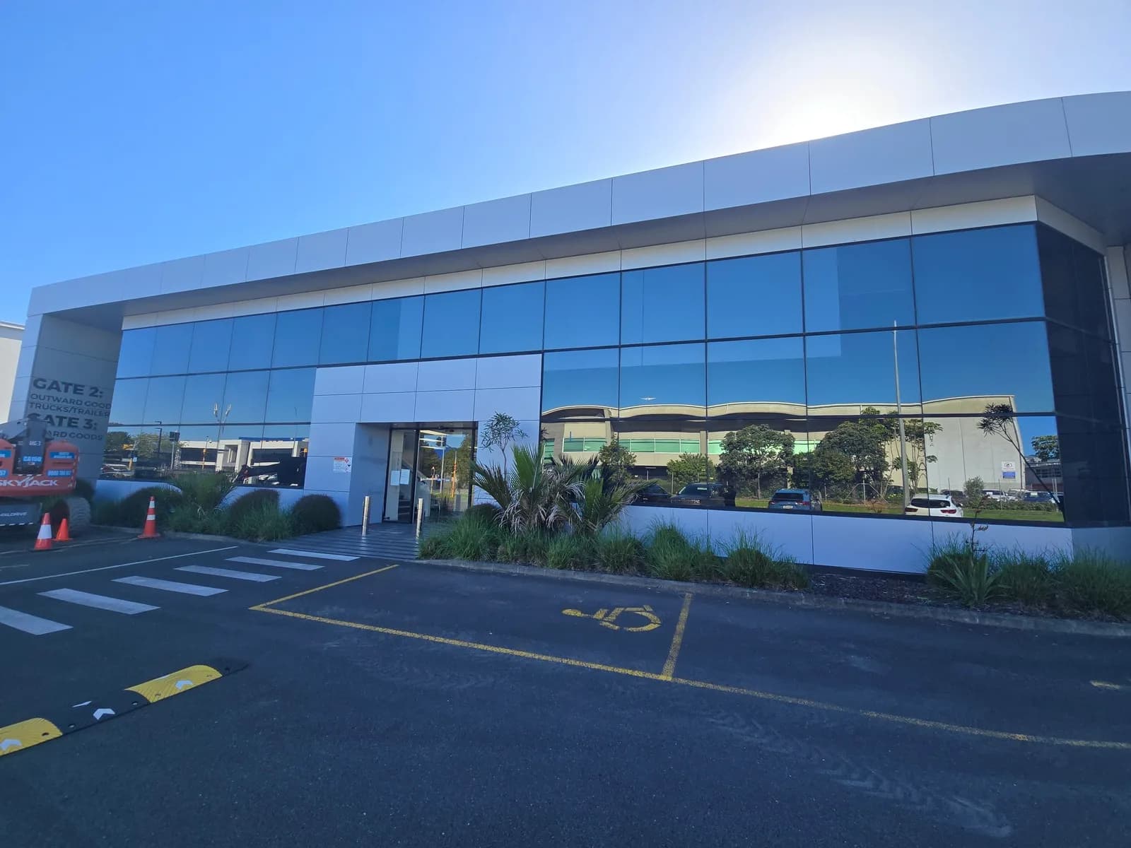 Commercial office building with a long glass frontage and silver cladding, after its cladding was repainted