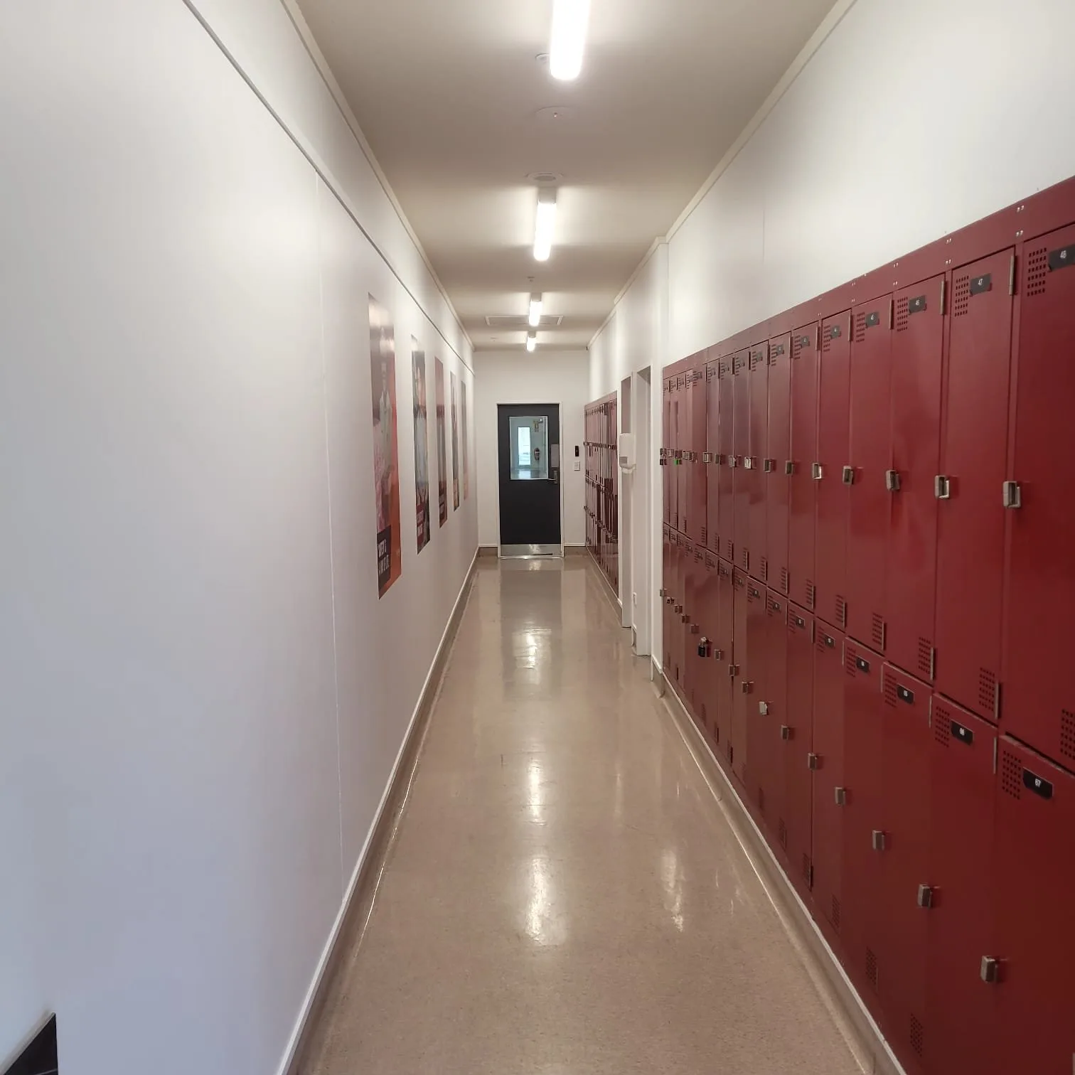 School corridor with white painted walls and a row of red lockers