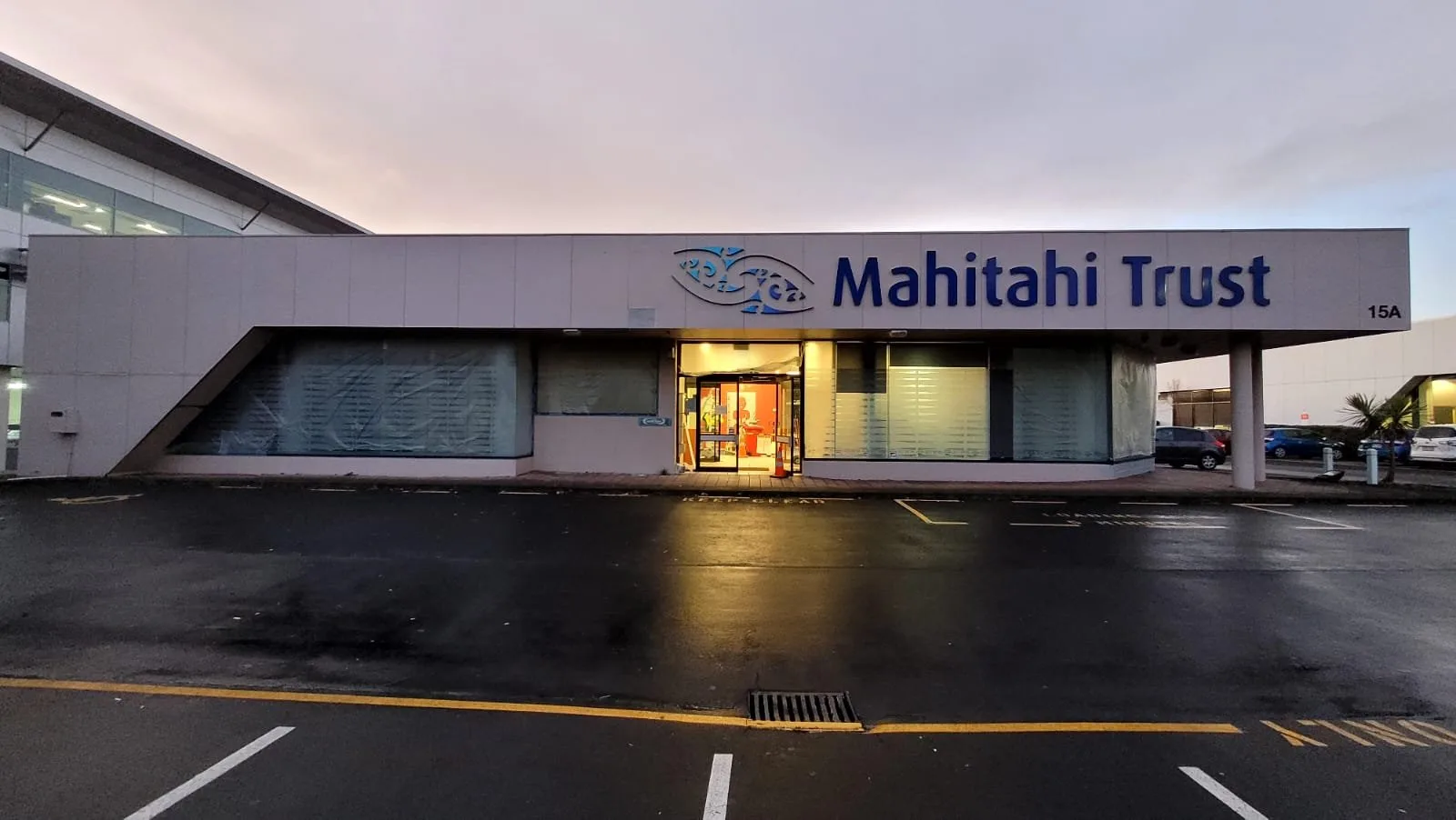 Repainted commercial building and car park at dusk
