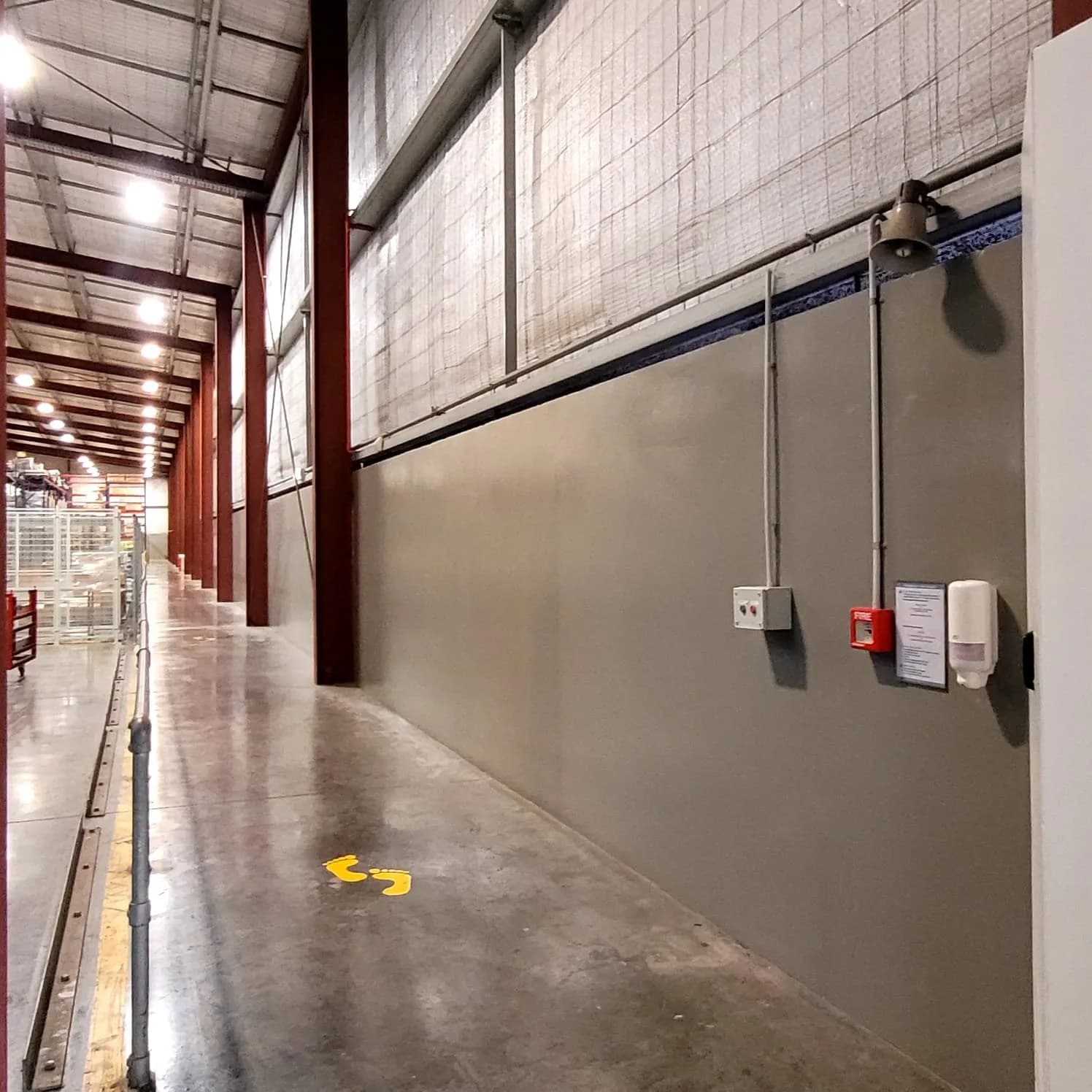 Industrial warehouse walkway with walls painted grey and red structural steel
